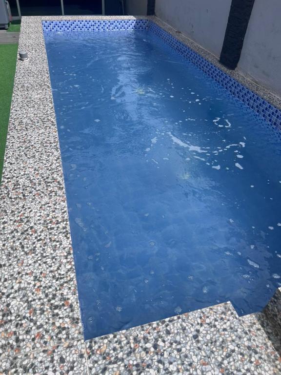 a pool of blue water next to a building at POOL CaSSa Ardina pantai Batu hitam 4rooms in Kuantan