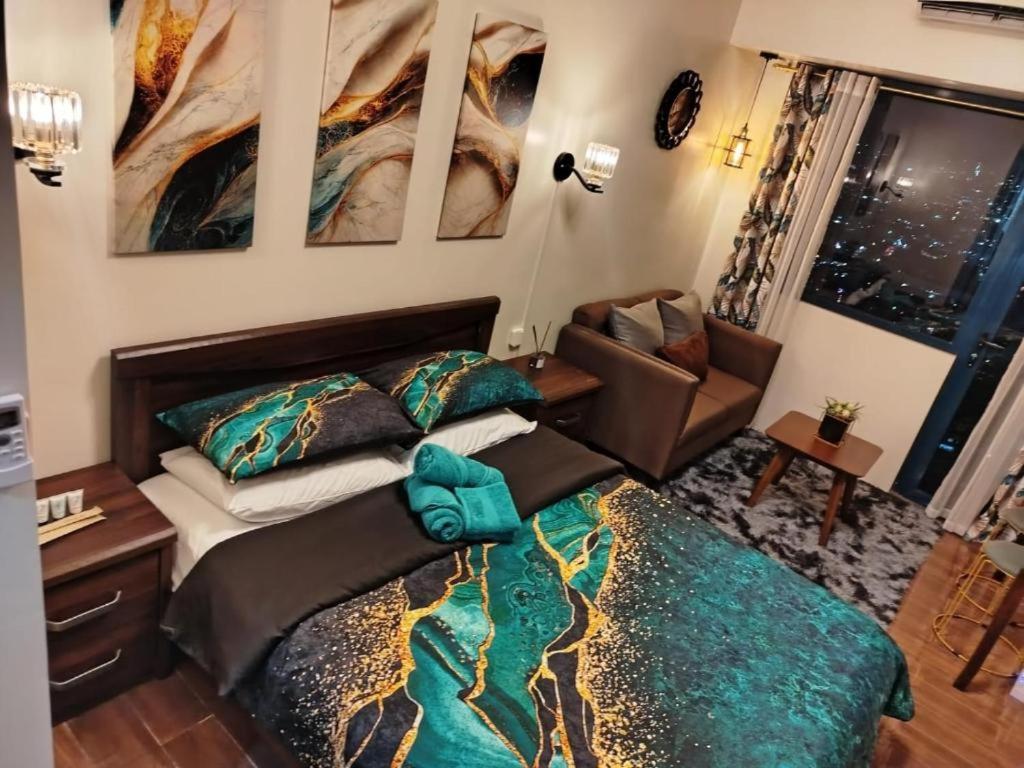 a bedroom with a bed and a couch in it at Air Residence-Sunset & City Views Await in Manila