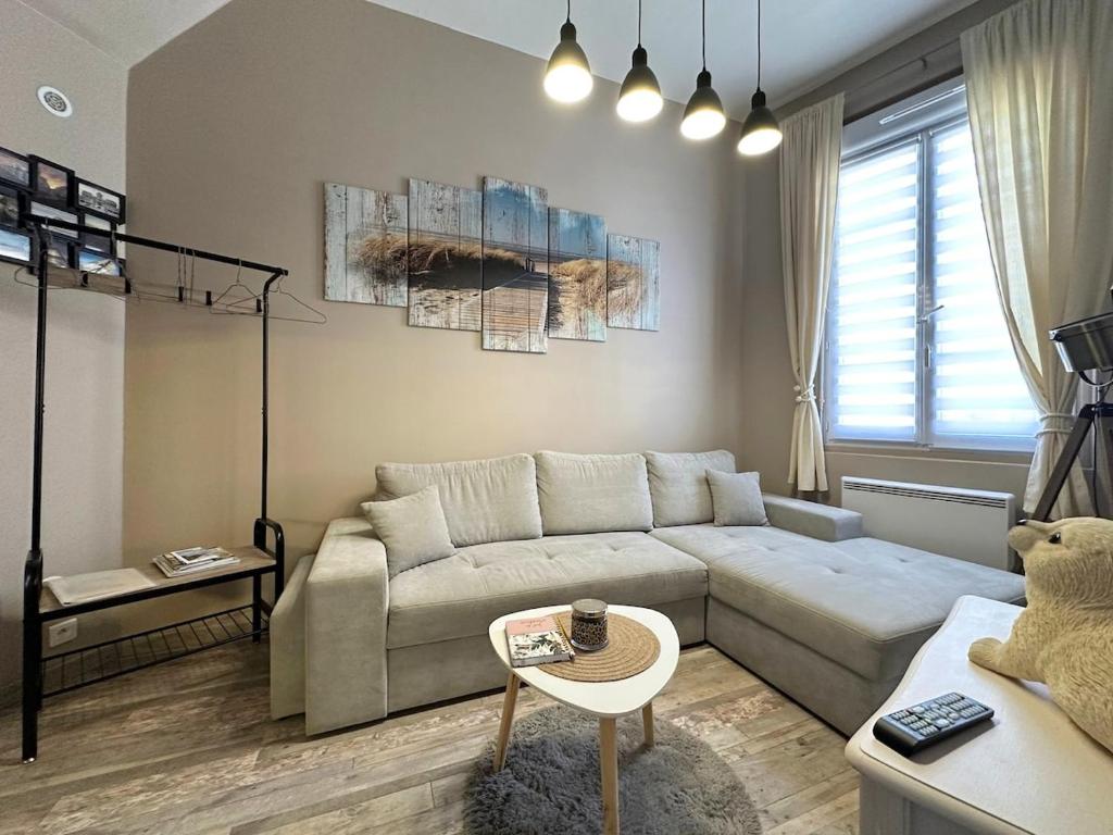 a living room with a couch and a table at A l'abri des vagues in Cayeux-sur-Mer