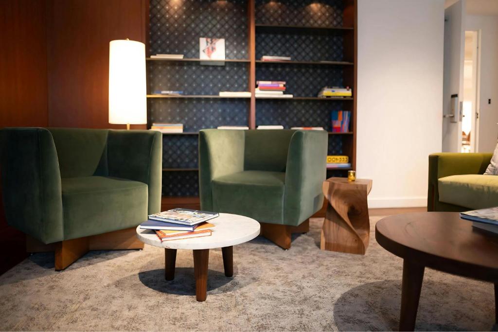 un soggiorno con 2 sedie verdi e un tavolo di Hotel 55 a Chicago