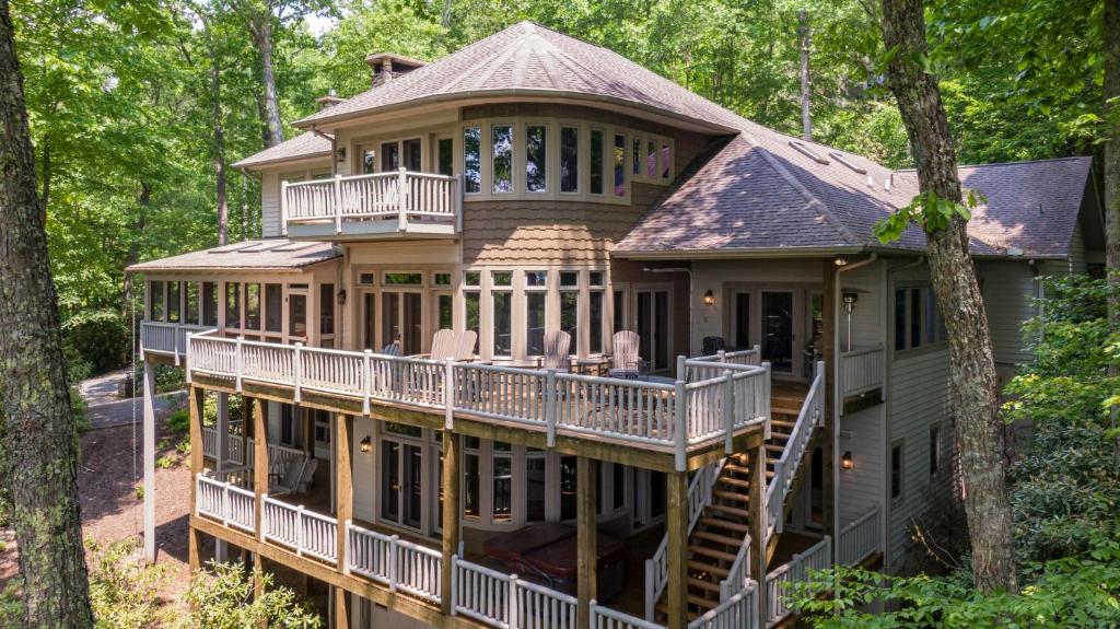 a house in the woods with a wrap around deck at Amitola at Yonahlossee in Boone