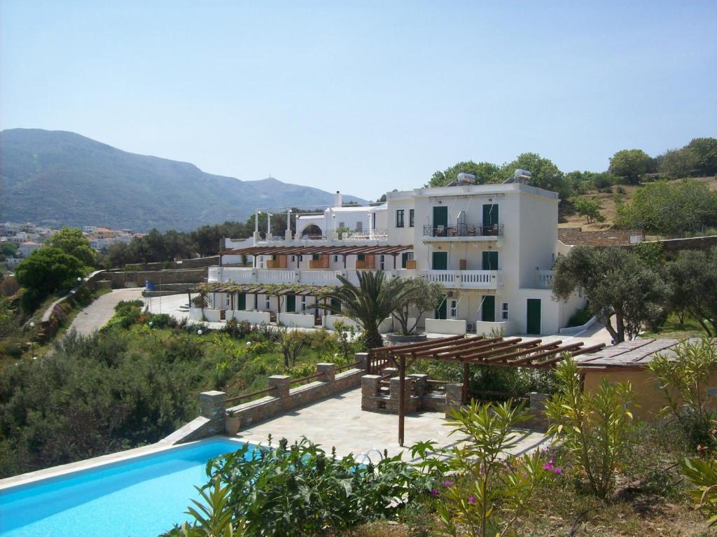 a large house with a swimming pool in front of it at Vassiliki Studios in Andros