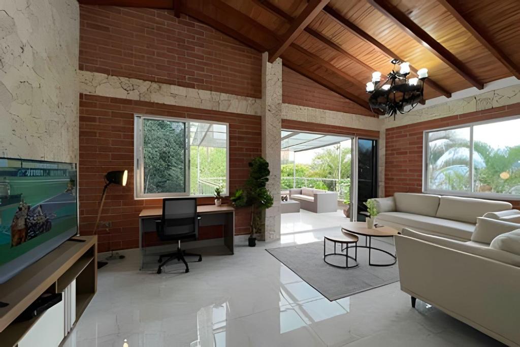 a living room with a couch and a tv at Palos altos house Poblado 6 min to Provenza in El Poblado