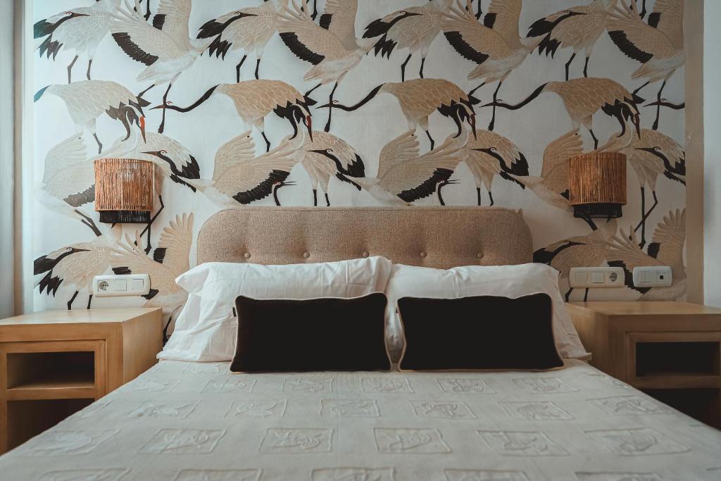 ein Schlafzimmer mit einem Bett mit einer Vogeltapete in der Unterkunft Hostal Boutique El Rey del Sol in Alora