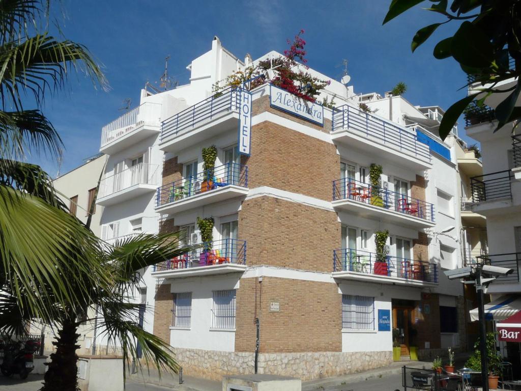 a building with flowers on the balconies of it at Hotel Alexandra Sitges in Sitges