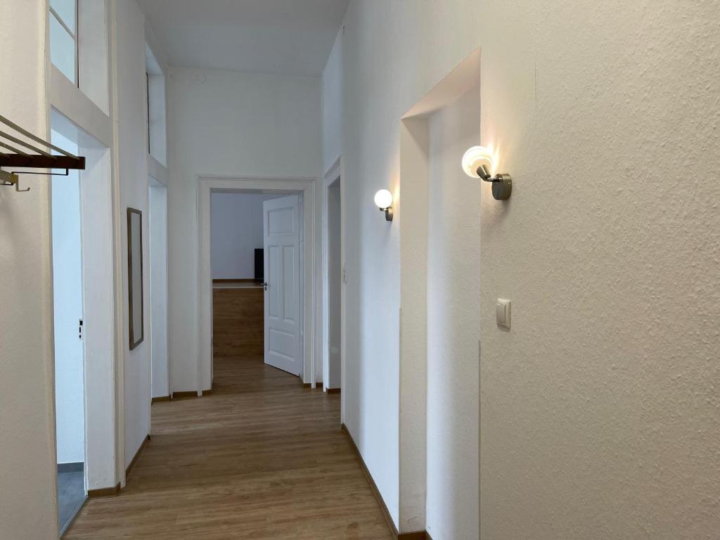 ein leerer Flur mit weißen Wänden und Holzböden in der Unterkunft Ferienwohnungen Neumann in Bamberg