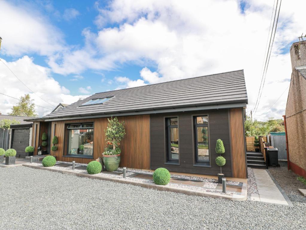 a small house with a black roof at Scotia At The Brig in Brydekirk