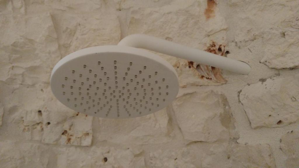 a white strainer on top of a stone wall at Dimora Sumerano in Alberobello