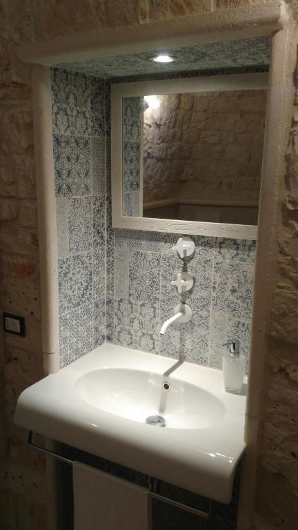 a bathroom with a white sink and a mirror at Dimora Sumerano in Alberobello