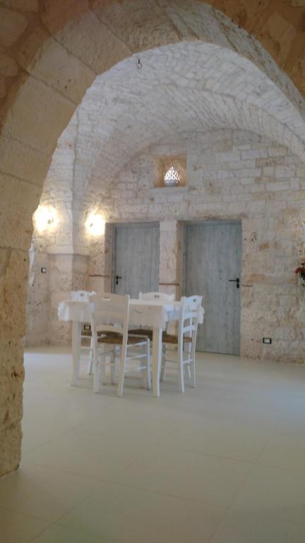 a dining room with white tables and white chairs at Dimora Sumerano in Alberobello