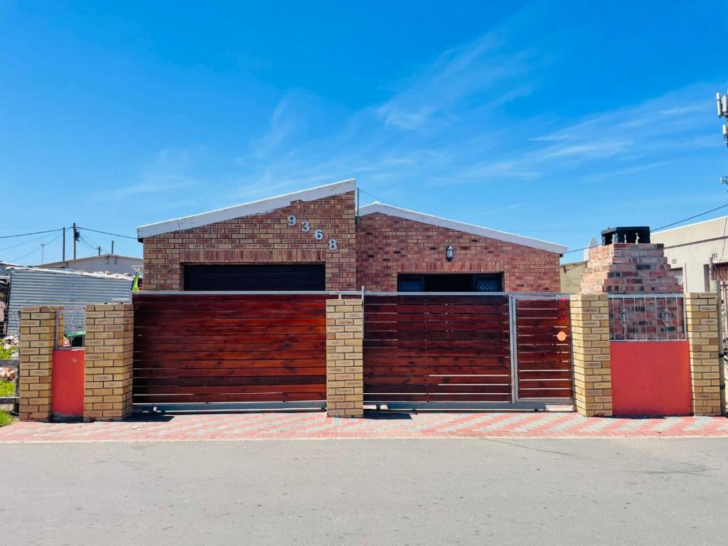 ein rotes Backsteingebäude mit einer roten Garage in der Unterkunft Cozy Stayz in Hermanus