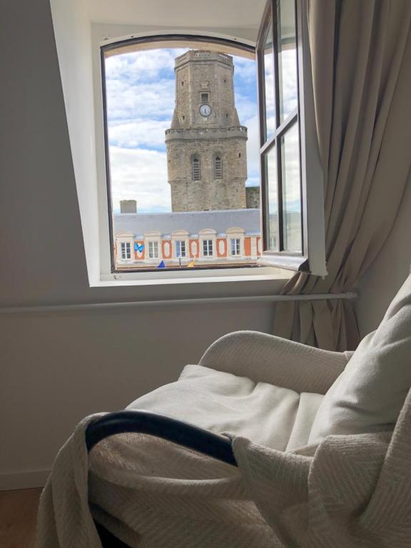a window with a view of a clock tower at Le Godefroy de Bouillon in Boulogne-sur-Mer