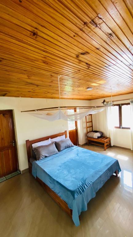 a bedroom with a bed with a wooden ceiling at Minerva Apart in Ranomafana
