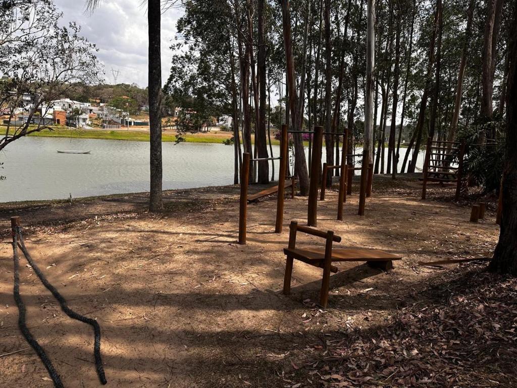 a park with a bench next to a body of water at Recanto dos Sonhos Ninho Verde 2 in Pardinho