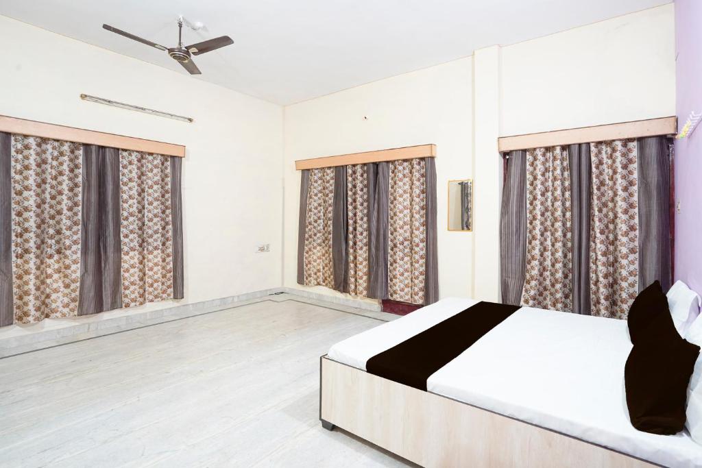 a bedroom with a bed and large windows at SPOT ON Muskan Lodge & Restaurants in Jāmul