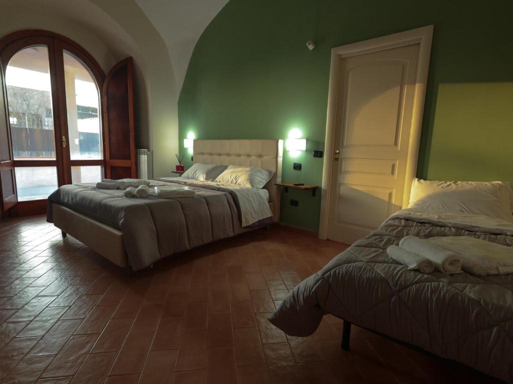 two beds in a room with green walls at Residence Stella in Pomigliano dʼArco