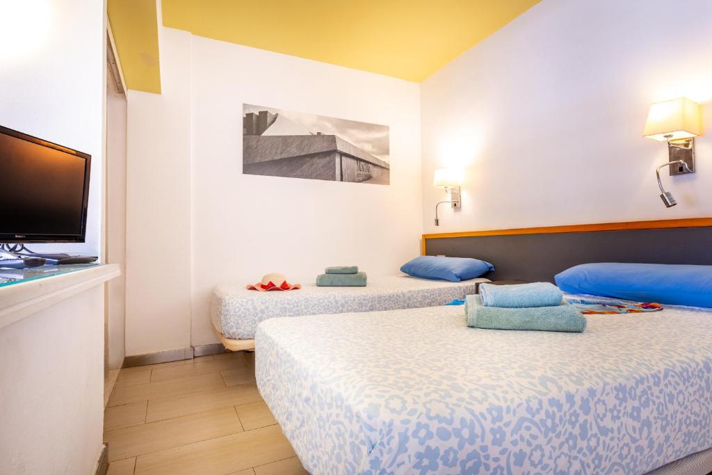 una habitación de hotel con dos camas y un televisor de pantalla plana en Charming apartment with an excellent location, en Arona