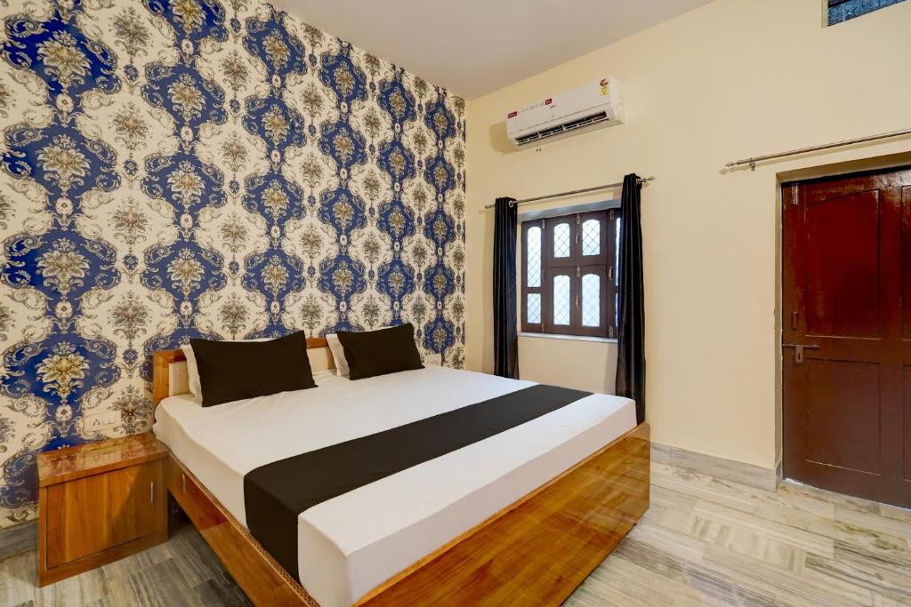 1 dormitorio con 1 cama y una pared azul y blanca en SPOT ON Ksg Bakery, en Mandor