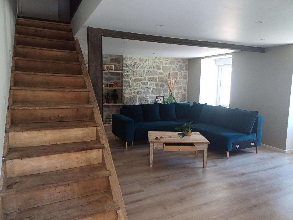 a living room with a blue couch and a table at La belle cachée in Sévérac d' Aveyron