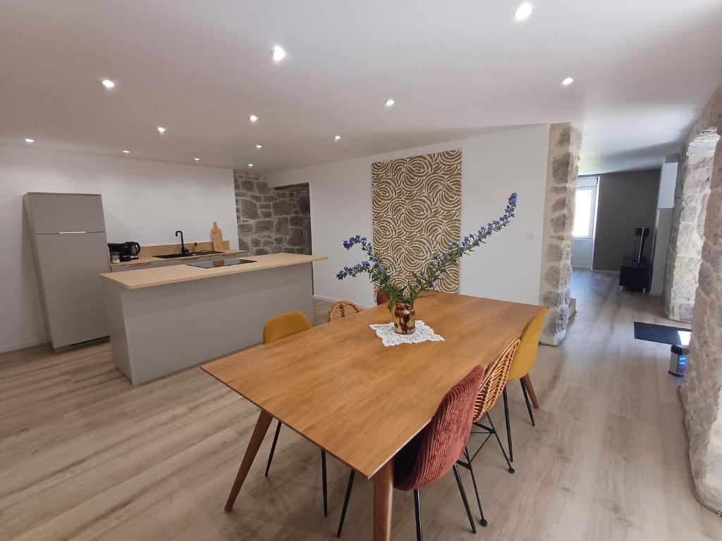 a kitchen and dining room with a wooden table and chairs at La belle cachée in Sévérac d' Aveyron