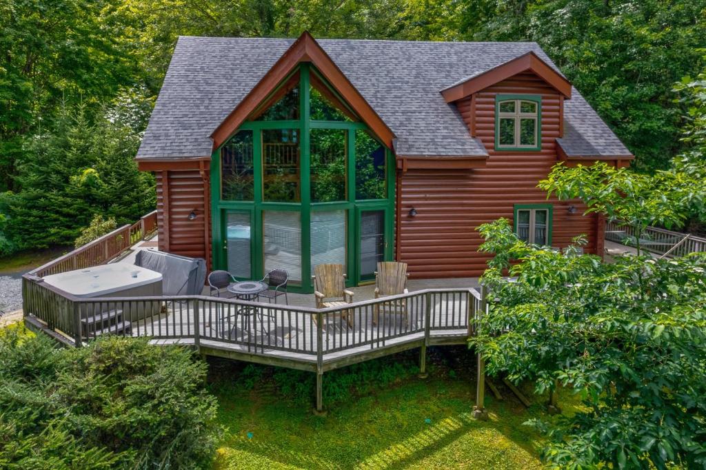 a cabin with a deck with a hot tub at Misty Peak in Banner Elk