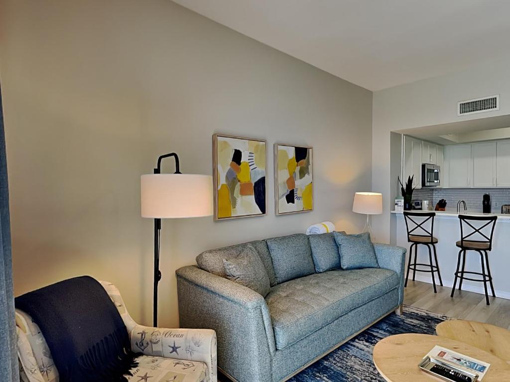 a living room with a couch and a kitchen at Inn at Summerwinds #1403 in Navarre