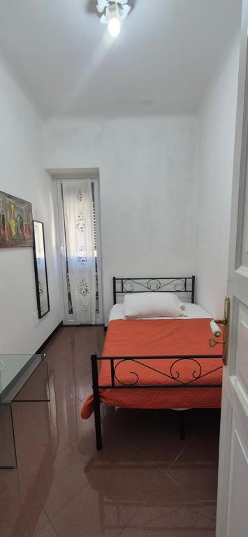 a white room with a bed with a red blanket at San Vincenzo B in Genoa