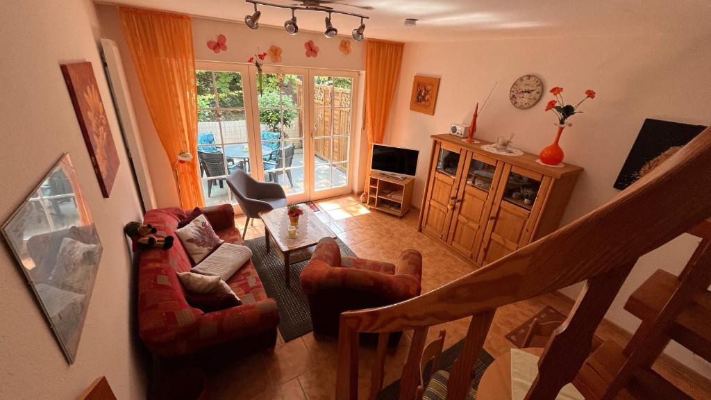 - un salon avec un canapé, des chaises et un escalier dans l'établissement Ferienhaus Barbara am Meer, à Horumersiel