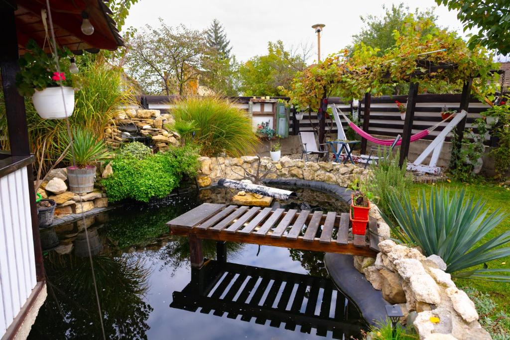 a pond with a wooden bench in a garden at AMA house in Alba Iulia