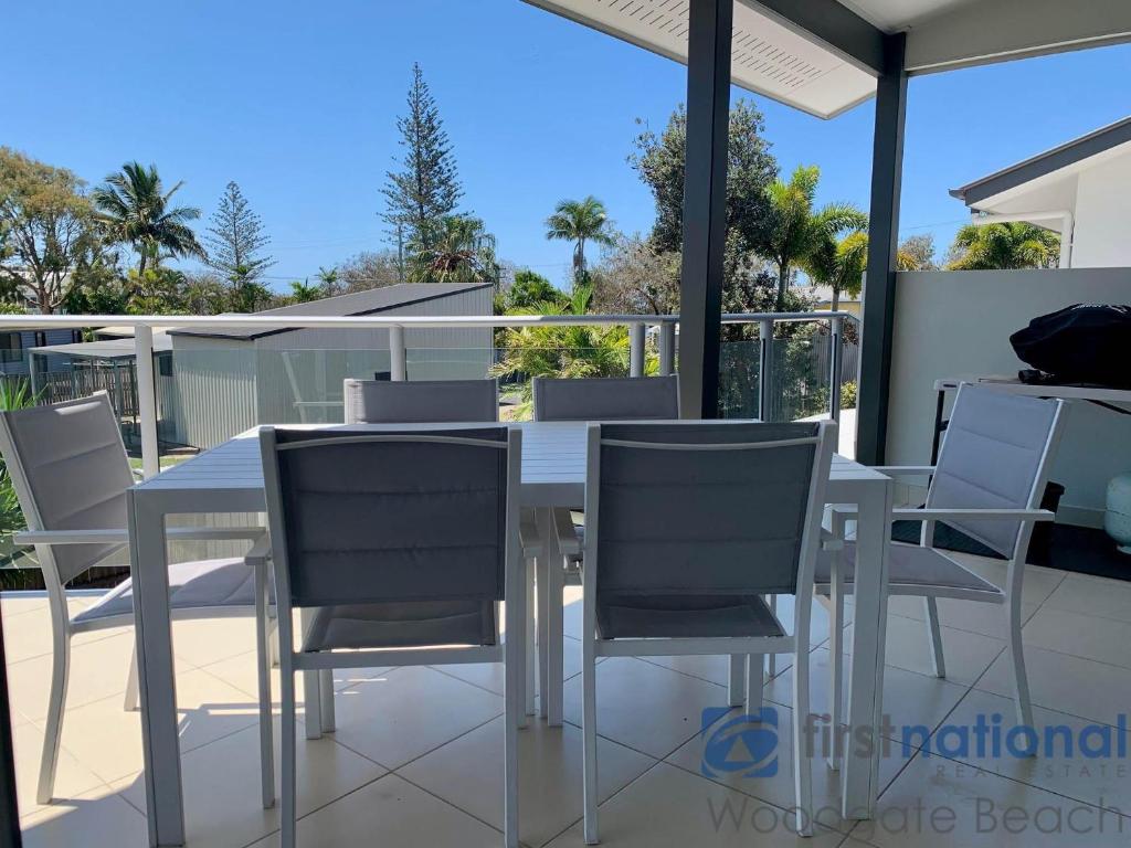 a white dining table and chairs on a balcony at 4/139 The Esplanade in Woodgate