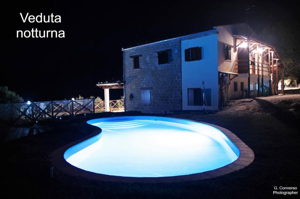 a swimming pool at night in front of a house at Agriturismo Pattina in Pettineo