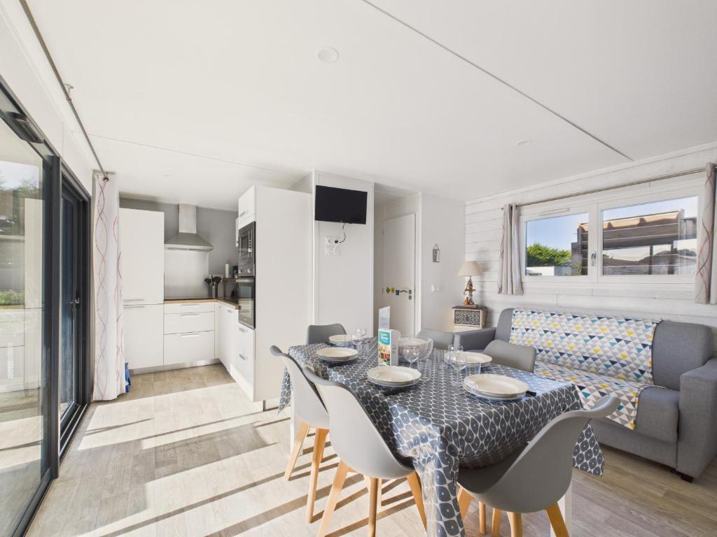 ein Esszimmer und ein Wohnzimmer mit Tisch und Stühlen in der Unterkunft Chalet pour 6, domaine avec piscine in Saint-Hilaire-de-Riez