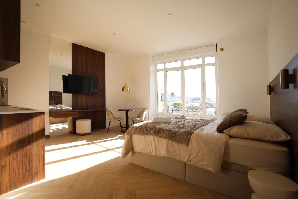 ein Schlafzimmer mit einem Bett und einem großen Fenster in der Unterkunft Résidence du Lion in Belfort