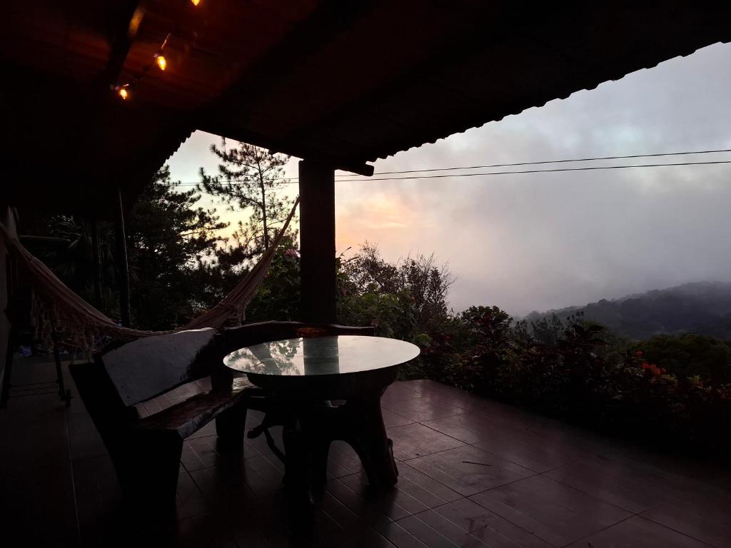 a table and a chair on a porch with a view at Hacienda Mi Montañita in Los Altos de Cerro Azul