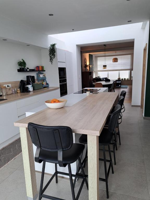 a kitchen with a wooden table and black chairs at Grande maison familiale à Theux in Theux