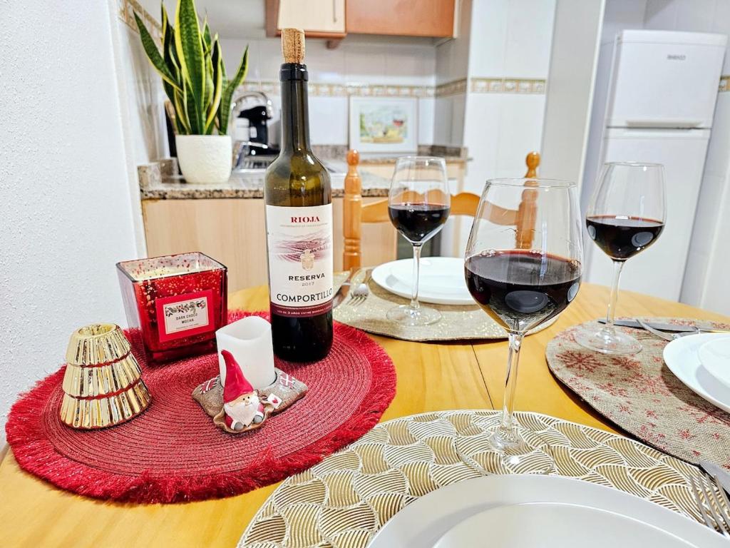 a table with a bottle of wine and two glasses at Piso Romántico con piscina in Formentera de Segura