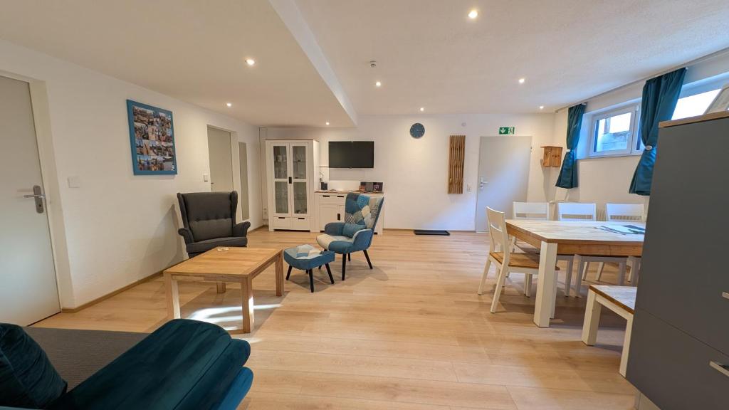 a living room with a table and chairs and a dining room at Zentrumsnahe, ruhige Souterrainwohnung AlBaggers in Dinkelsbühl