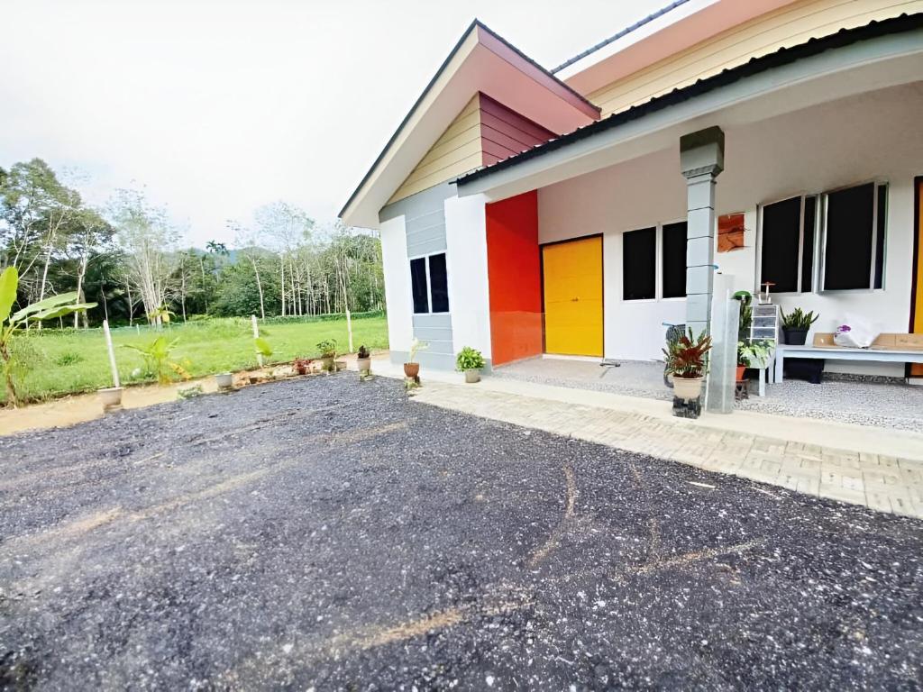 a house with colorful doors and a parking lot at Aufa House in Padang Rengas