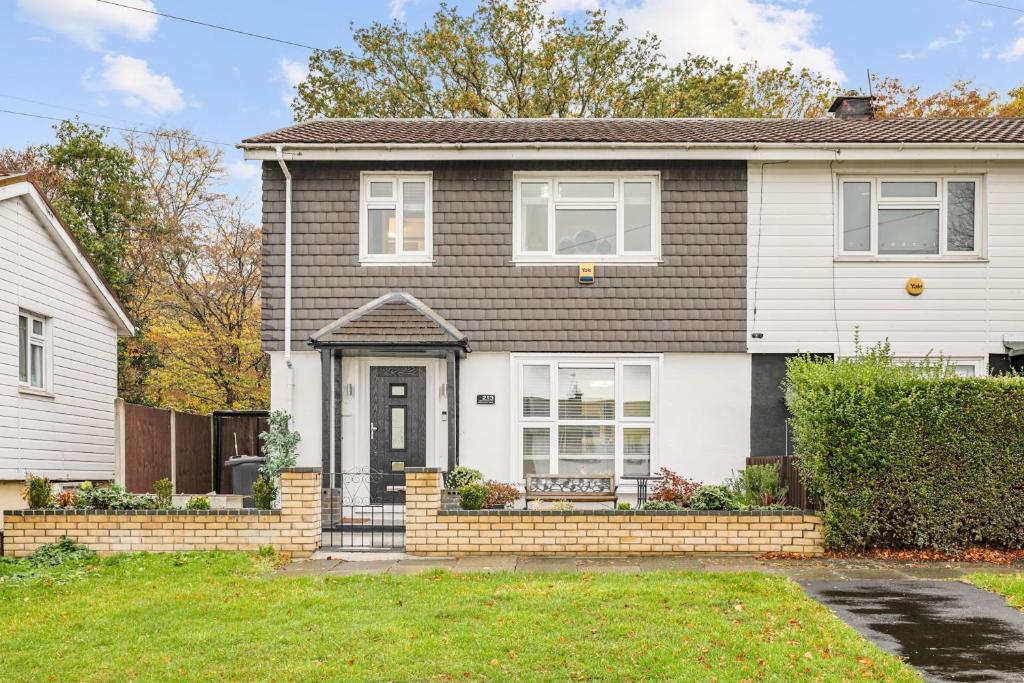 a white house with a black door at Pass the Keys Modern 3Bed Garden Parking Nr Hainault Station in Chigwell