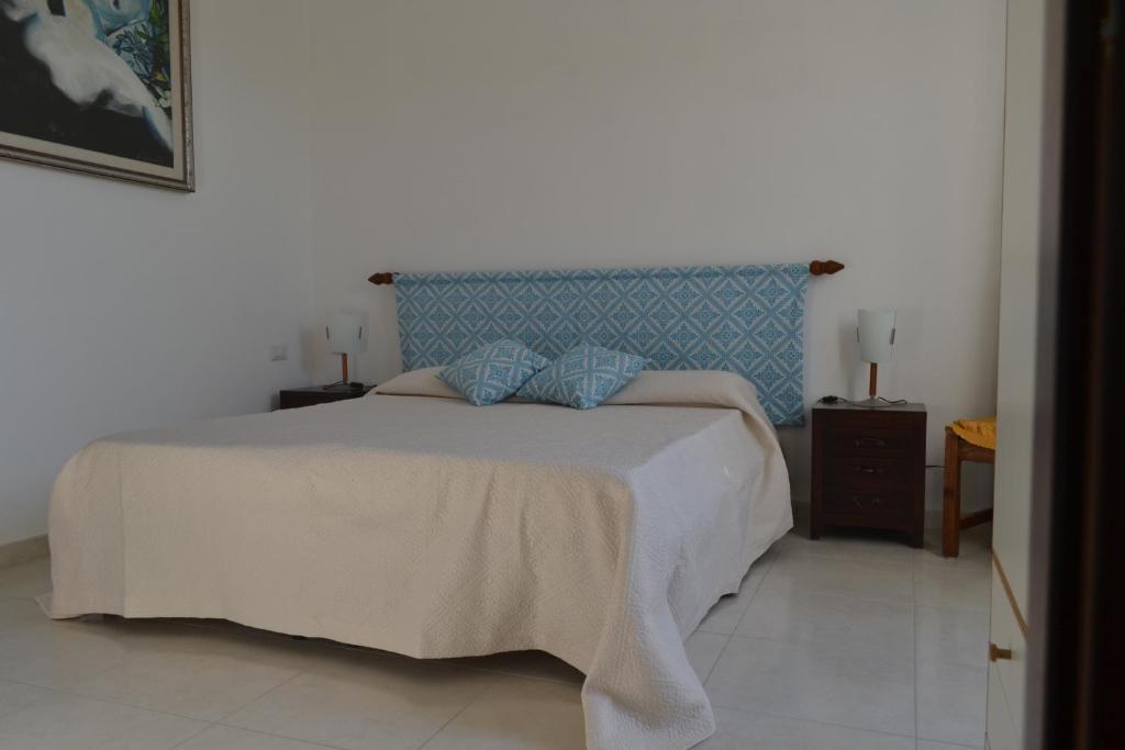 アルゲーロにあるB&B l'Antropologoのベッドルーム1室(大型ベッド1台、青いヘッドボード付)