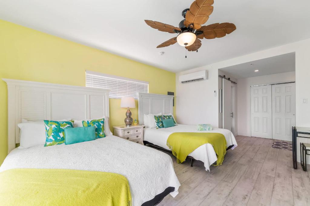 ein Schlafzimmer mit zwei Betten und einem Deckenventilator in der Unterkunft The Banana Bird at Cottages in Sand Bluff
