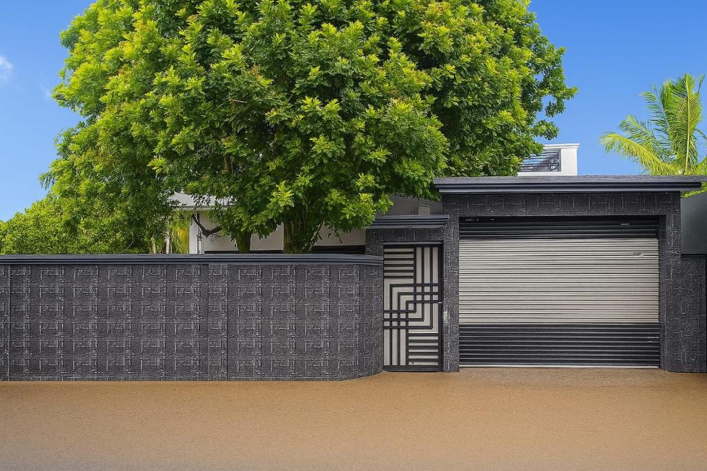 a house with a garage and a tree at Arrow Villas in Meda-Ela