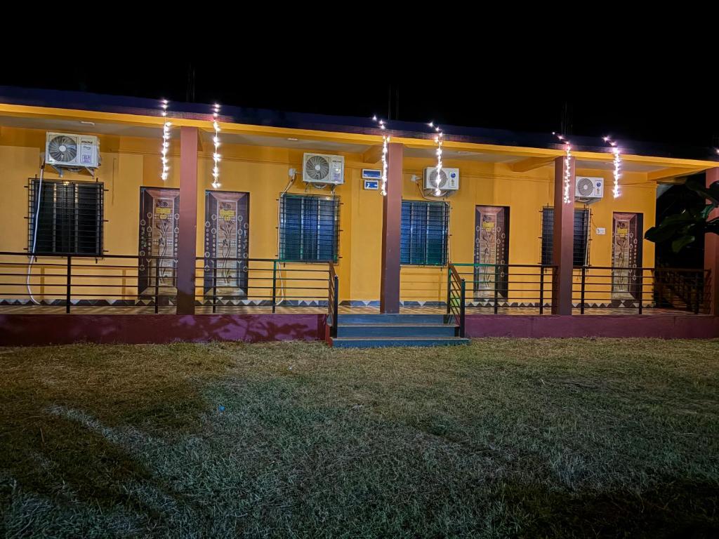 マルバンにあるHotel Vedanshの夜間照明付きの黄色い建物