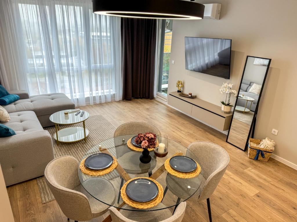 un soggiorno con tavolo e sedie in vetro di 2BР Apartment in a Modern Complex a Plovdiv