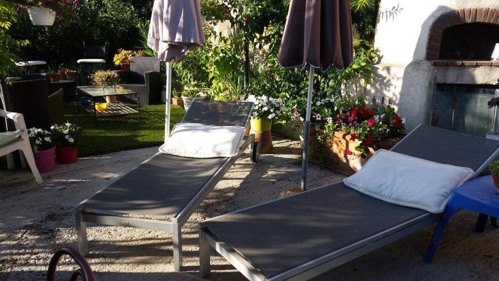 two beds and an umbrella in a yard at La Tuiliere in Saint-Laurent-du-Var