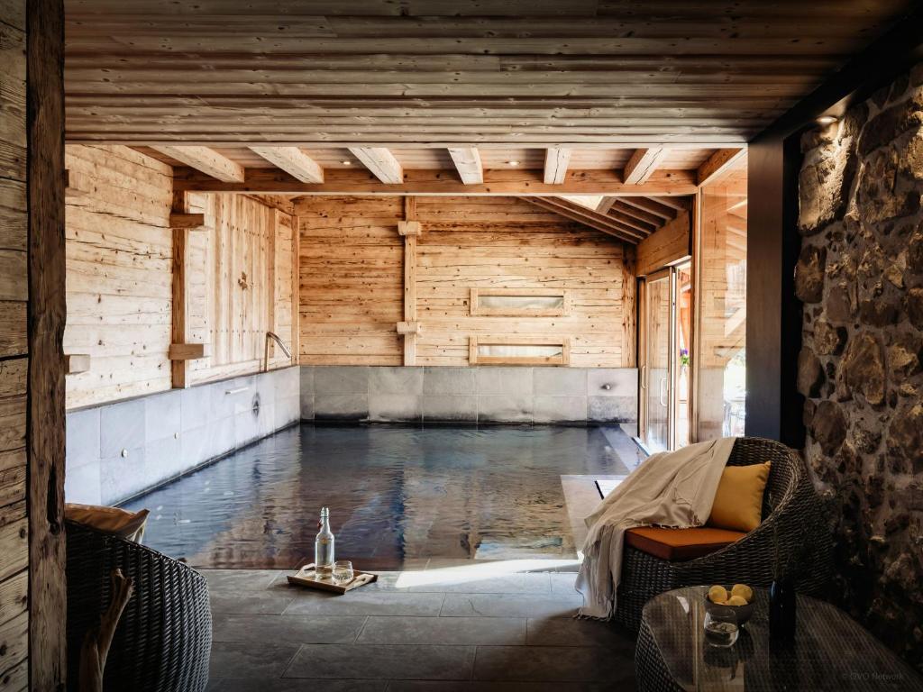 a swimming pool in a room with a wooden wall at Chalet Ladroit - OVO Network in Les Clefs