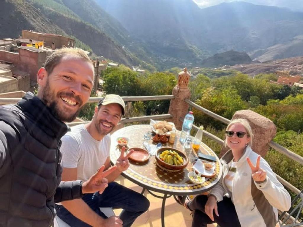 a group of three people sitting around a table with food at The Imlil escape Retreat in Tamatert