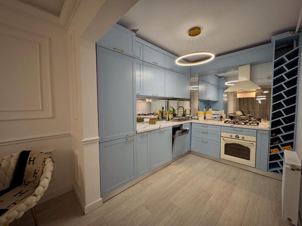 una grande cucina con armadi blu ed elettrodomestici di Boutique Apartment 2 a Ploieşti