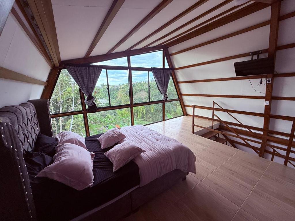 a bed in a room with a large window at Finca de Descanso El Ocaso in Sevilla