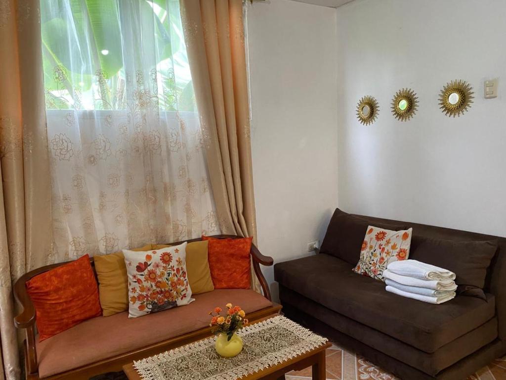 Una sala de estar con dos sofás y una ventana. en Los Tamarindos Posadamanabita, en Portoviejo